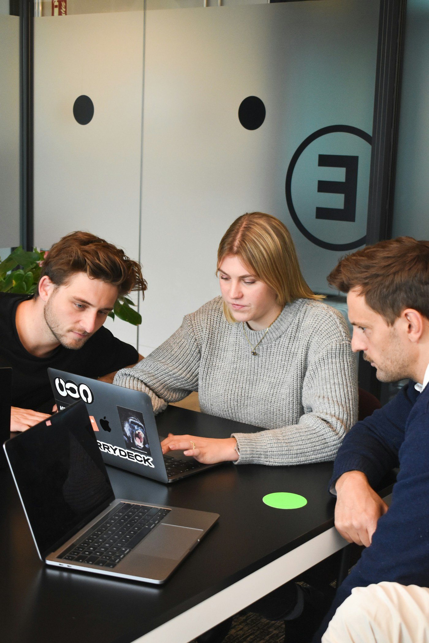 Colleagues reviewing work together around a laptop